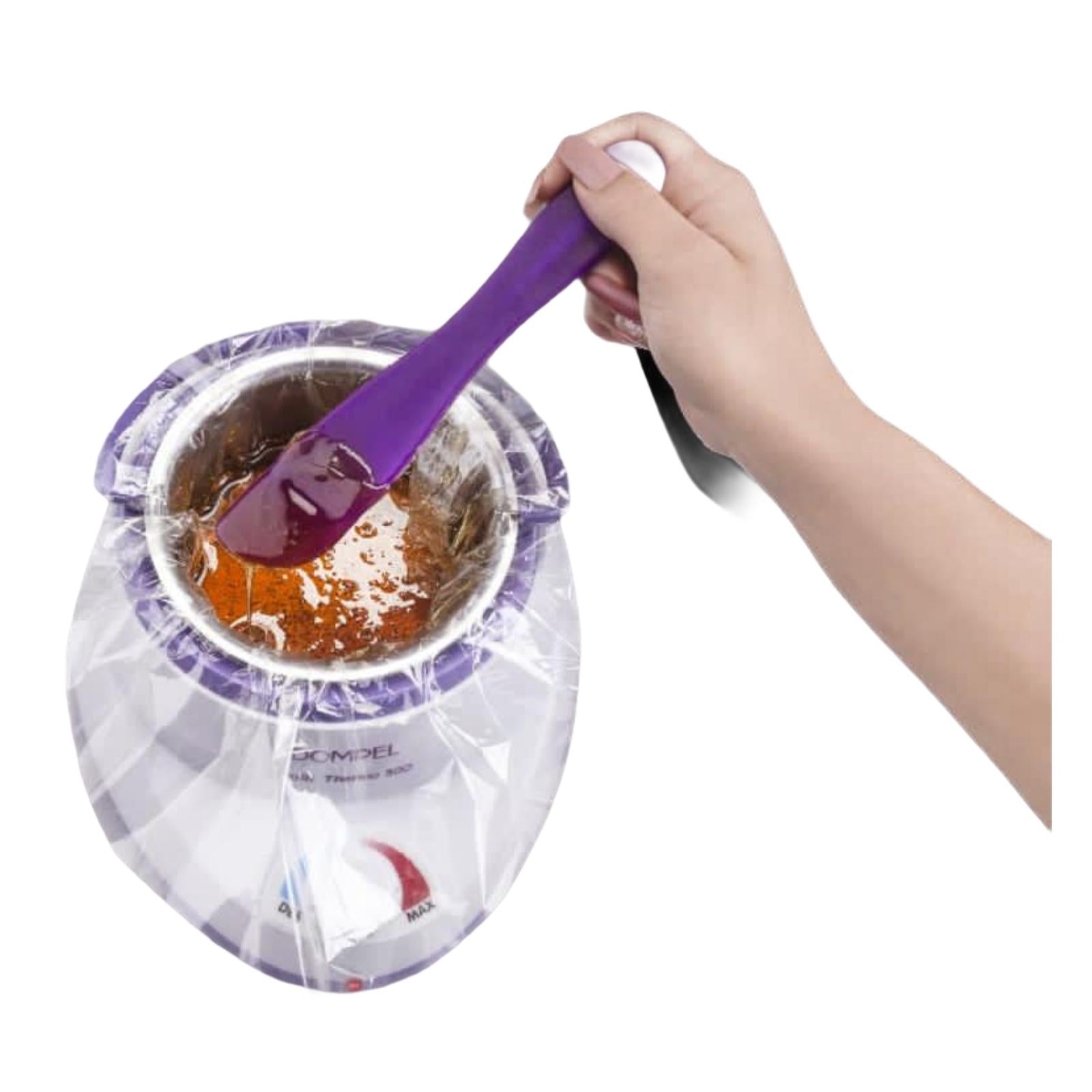 Dompel wax warmer with melted wax and plastic refill, showcasing the waxing process with a spatula